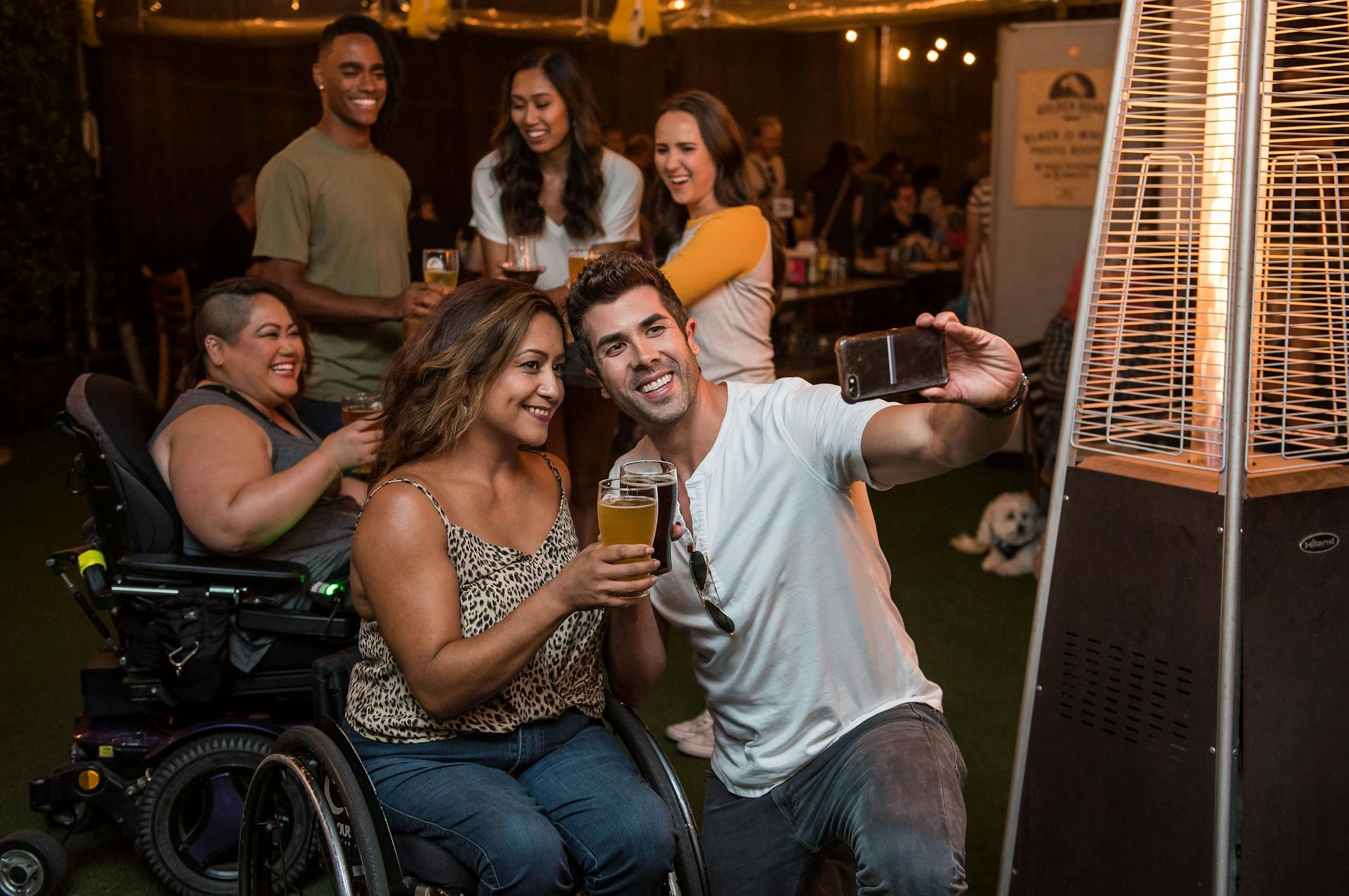 Man taking photo with woman holding drink/