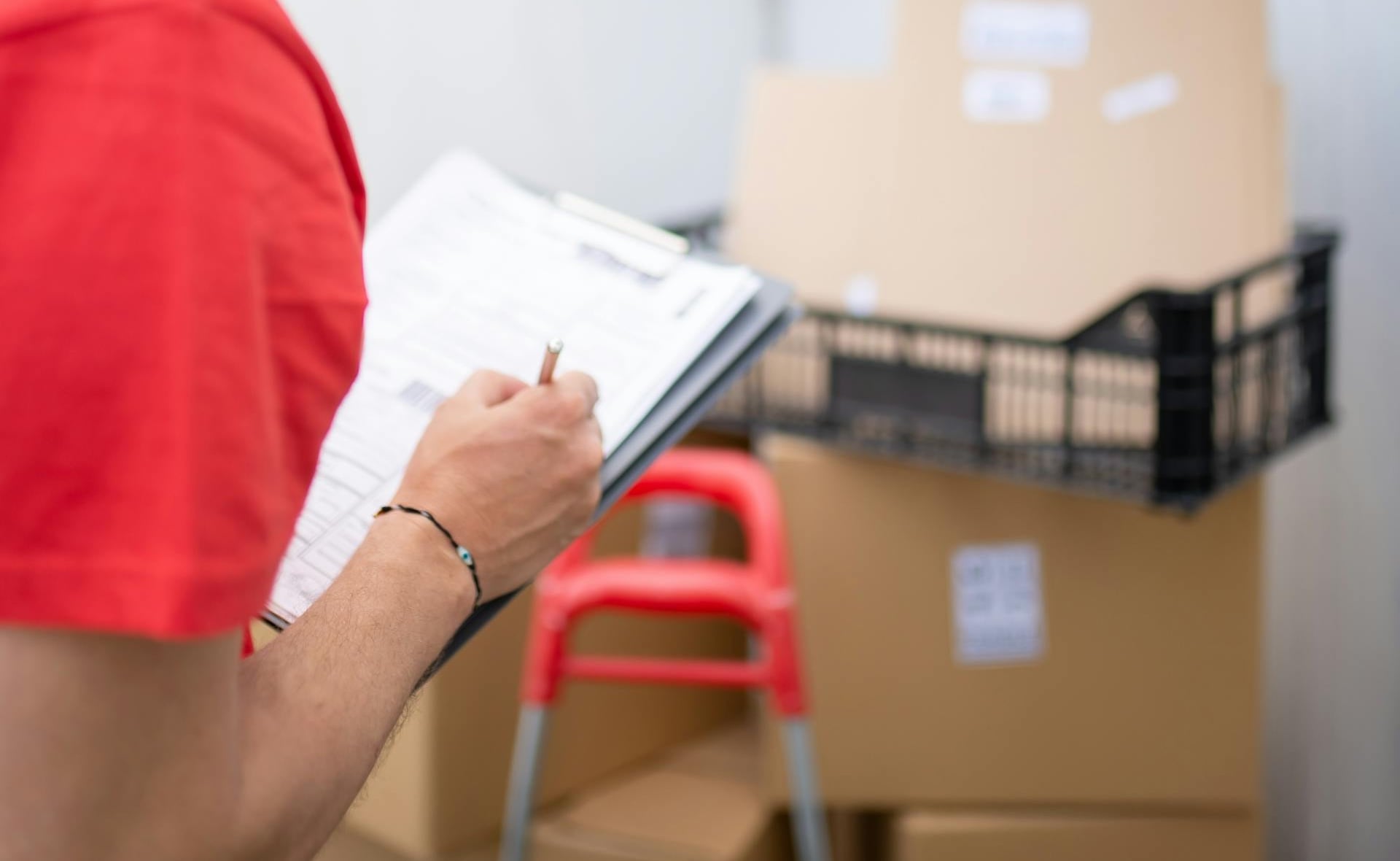 Man in red t-shirt holding white printer paper